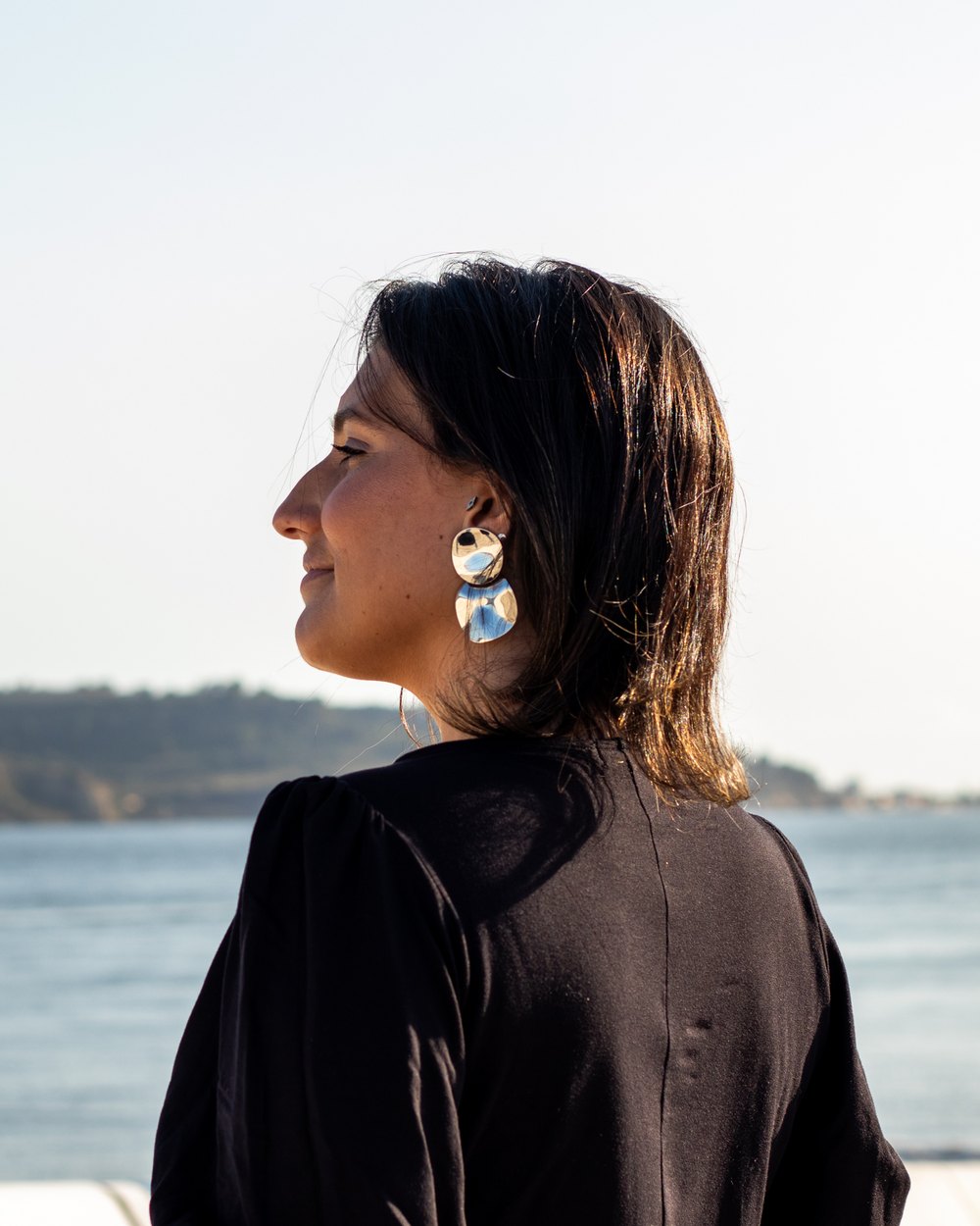 Carol Ferreira de perfil, olhando o rio